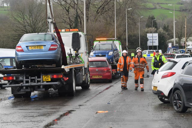 Cars damaged by flood water are retrieved by a recovery crew on Oxford Street, Nantgarw (Ben Birchall/PA)