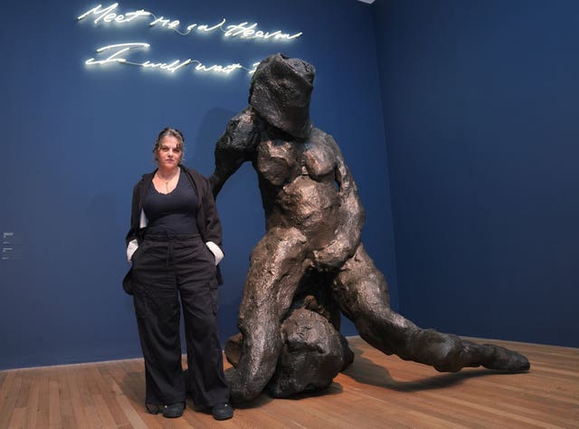Dame Tracy Emin stands next to her artworks I Will Not Be Alone, 2025, and neon sign Meet Me In Heaven I Will Wait For You, 2004