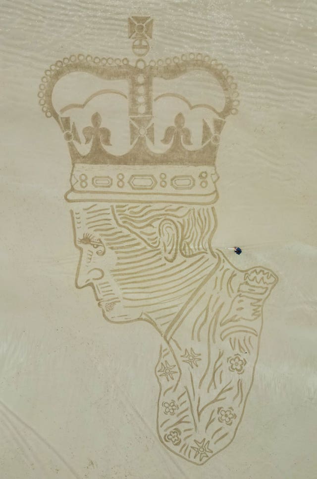 Sand artist Claire Eason from Sunderland puts the finishing touches to her 90 ft by 65ft sand sculpture of King Charles III on Bamburgh beach in Northumberland to mark the celebrations of King Charles III’s coronation this weekend