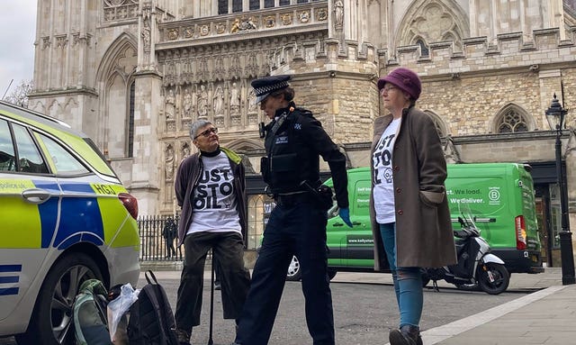 Two women with a police officer by a police car