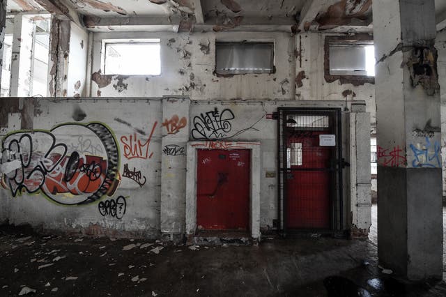 Graffiti by doorways and flaky paintwork inside the former Bristol Royal Mail sorting office (Ben Birchall/PA)