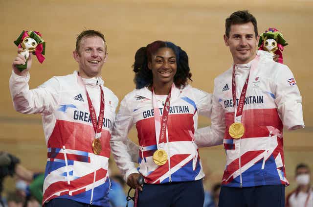 British cyclists Kadeena Cox, centre, Jaco van Gass, right, and Jody Cundy. left, celebrate on the podium in Tokyo