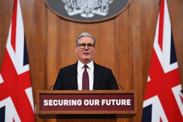 Keir Starmer behind a podium bearing the words 'securing our future' and flanked by Union flags