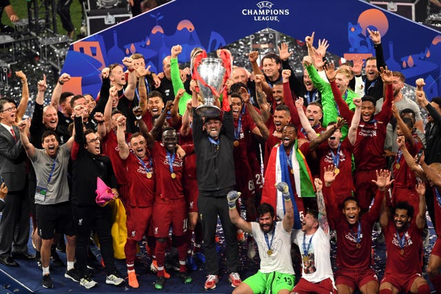 Jurgen Klopp, centre, and his Liverpool squad celebrate with the trophy after their Champions League win in 2019
