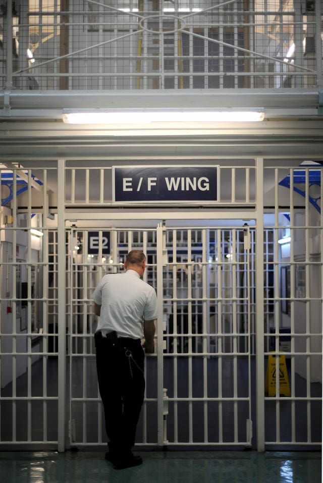 A guard in front of a gat inside a prison