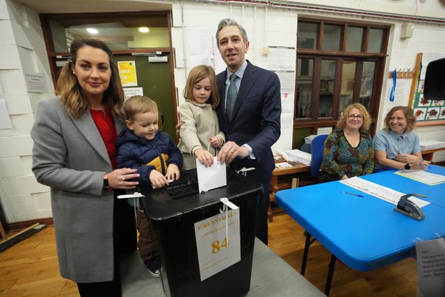 Simon Harris's son and daughter help him and his wife drop their votes into a ballot box