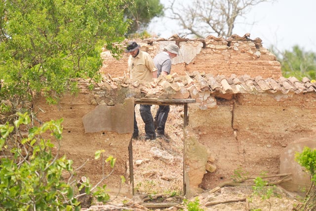 Search teams look through a derelict property