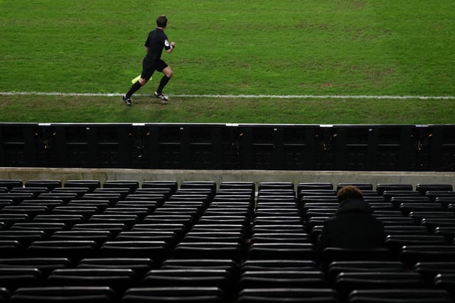 A referee's assistant runs past during MK Dons' home defeat to Blackpool