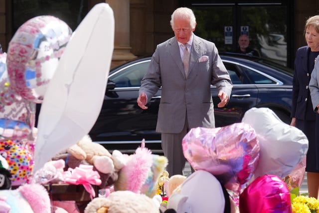 The King views the flowers and tributes outside the Atkinson Art Centre Southport ahead of meeting members of the Southport community 