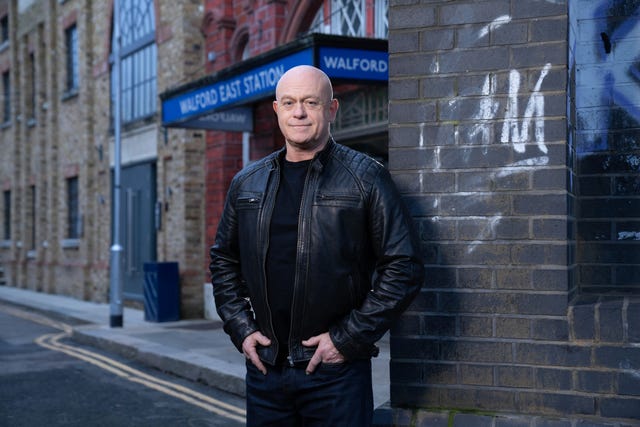 Ross Kemp in character on the EastEnders set, with Walford East Station behind him