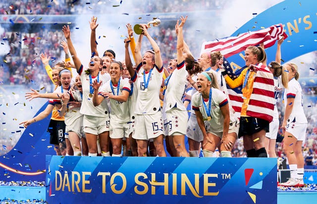 The United States celebrate as captain Megan Rapinoe, centre, lifts the 2019 Women's World Cup trophy