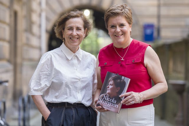 Nicola Sturgeon smiling while holding her book, standing alongside Kirsty Wark