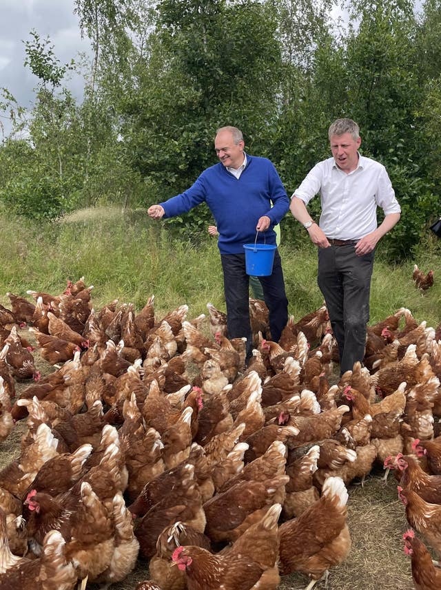 Liberal Democrat leader Sir Ed Davey, left, with Liberal Democrat candidate for Lewes James MacCleary feeding chickens during a visit to The Mac's Farm in Ditchling, East Sussex, while on the General Election campaign trail 