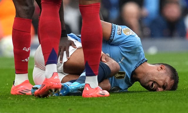 Rodri clutches his knee in pain after going down injured