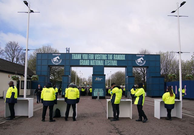 Stewards on an entrance wait for racegoers during day one of the Randox Grand National Festival at Aintree Racecourse