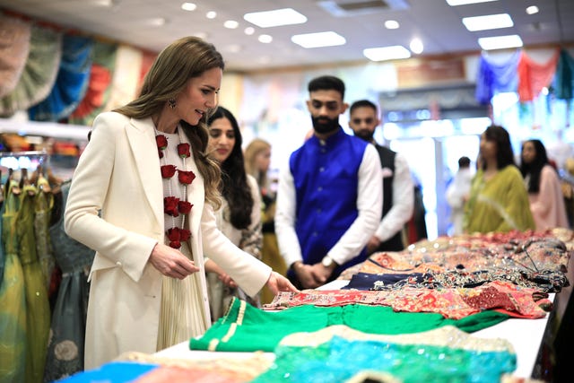 Kate touching a garment for sale at a sari shop