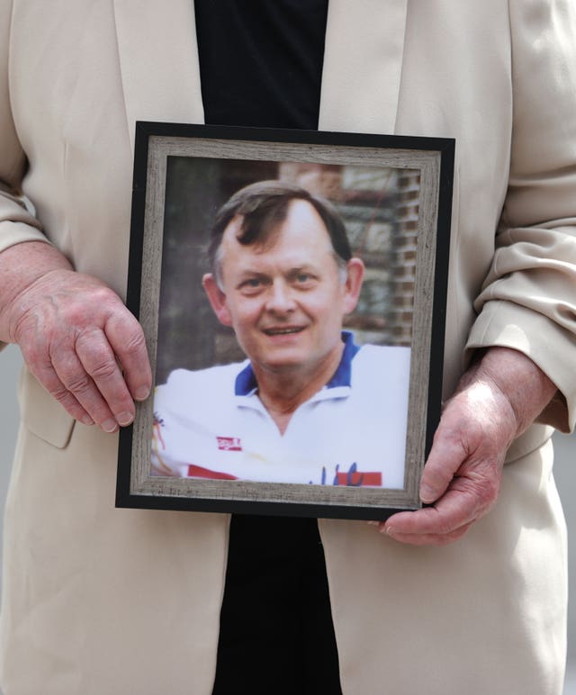 A person holding a framed photo of murdered GAA official Sean Brown