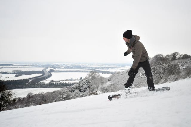 A person snowboards in Aston Rowant National Nature Reserve on the Chilterns escarpment, in Oxfordshire 
