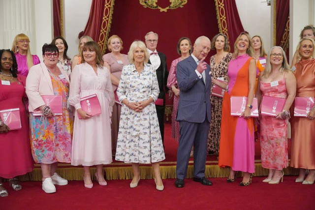 Charles and Camilla pose for a photo with Lorraine Kelly and members of the Change and Check choir 