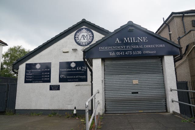 A white building with a sign saying A Milne Funeral Directors