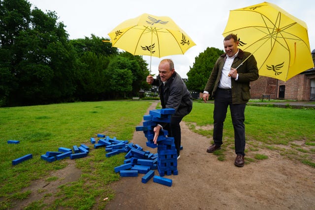 Liberal Democrats leader Sir Ed Davey and parliamentary candidate for Cheadle, Tom Morrison play Jenga with a giant blue set of bricks during a visit to Cheadle 