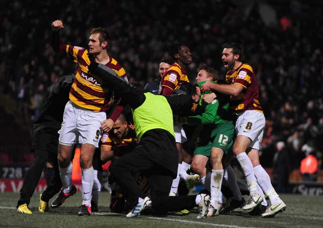 Bradford goalkeeper Matt Duke is mobbed by his team-mates after the penalty shoot-out