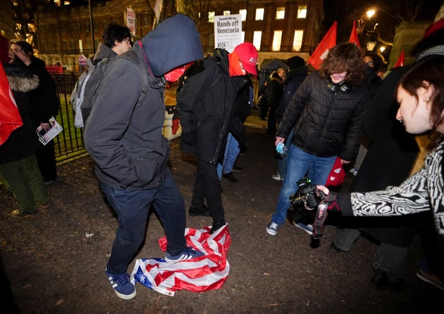 Campaigners stamp on the US flag during the demonstration