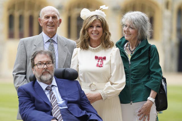 Kate Garraway, with her husband Derek Draper and her parents after being honoured with an MBE (Andrew Matthews/PA)