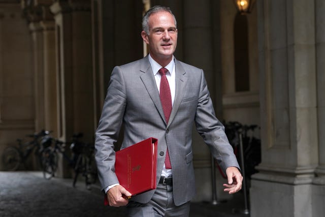 Technology Secretary Peter Kyle in grey suit holding a red file