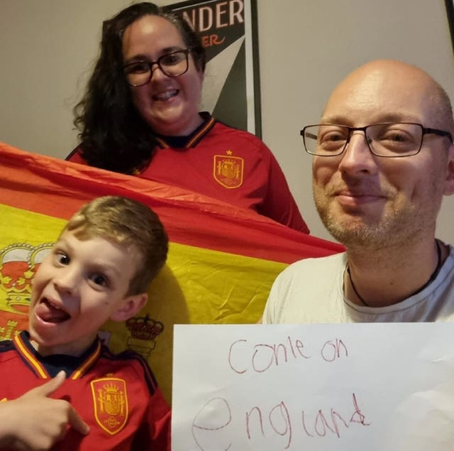 A child a woman and a man with a Spanish flag