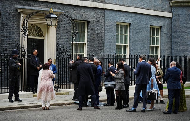 Members of the Muslim community queue as they wait to have their picture taken in front of 10 Downing Street’s door, as they arrive for an Eid reception in Downing Street