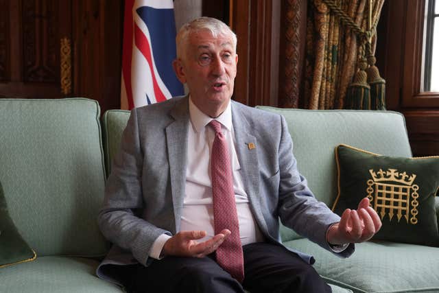 Sir Lindsay Hoyle sitting on a green couch next to a parliamentary cushion