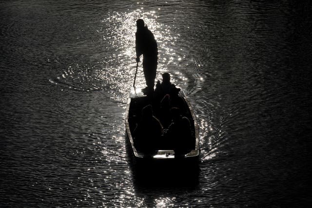 People wrap up warm as they punt along the River Cam on a cold day in Cambridge