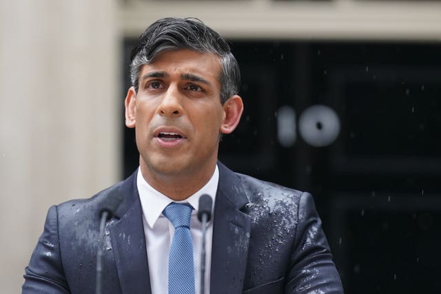Rishi Sunak in a soaking suit outside the door to Number 10 Downing Street