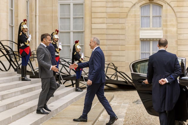 Taoiseach Micheal Martin is welcomed by French President Emmanuel Macron on the steps of the Elysee Palace in Paris, France