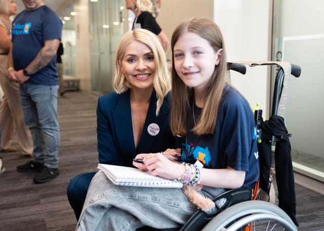 Holly Willoughby smiling alongside a girl in a wheelchair