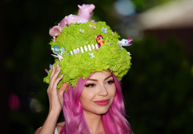 Woman with pink hair and green faux grass hat