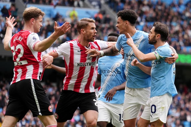 Manchester City captain Bernardo Silva, right, and Brentford's Nathan Collins, left, are separated by Kristoffer Ajer and Nico O'Reilly