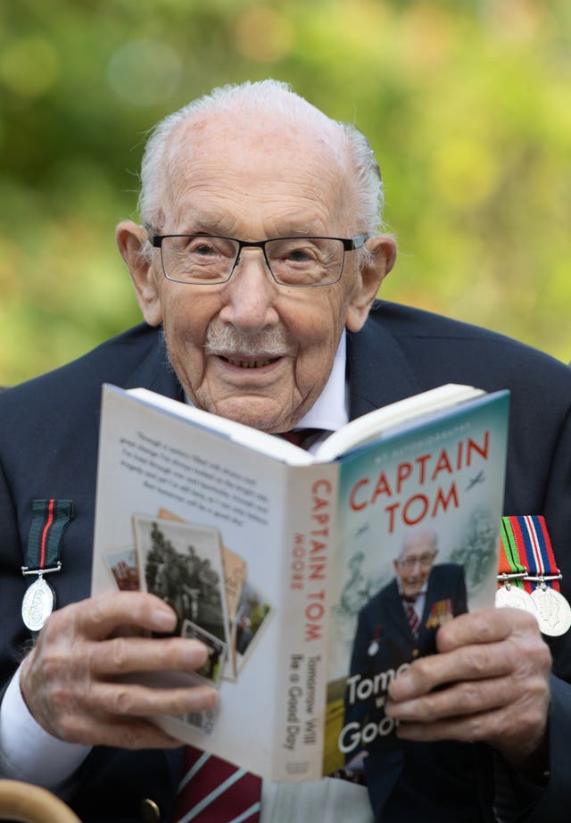 Captain Sir Tom Moore holds a copy of his autobiography