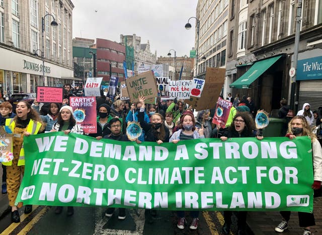 People take part in a climate change protest in Belfast.
