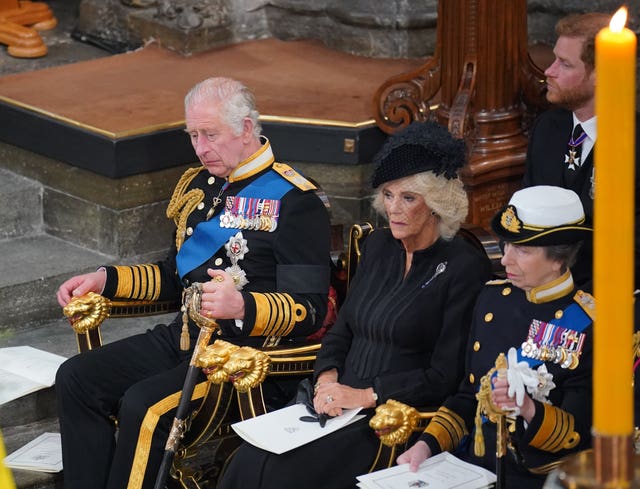 Charles with the Queen Consort and the Princess Royal in front of the Queen's coffin