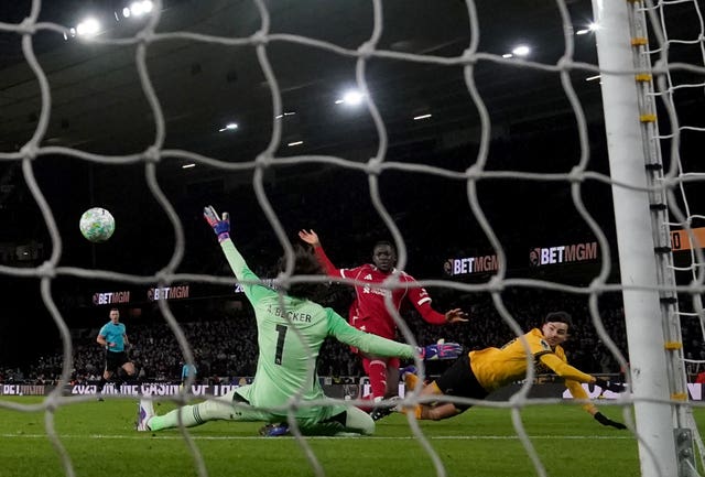 Rodrigo Gomes, right, scores Wolves' opener past Liverpool goalkeeper Alisson Becker, left, and defender Ibrahima Konate