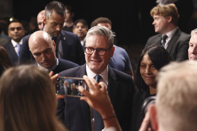 An audience member takes a photograph of Keir Starmer as he leaves Pinewood Studios following his 'plan for change' speech