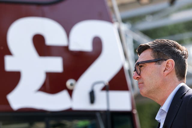 Prime Minister Andy Burnham in front of a FirstGroup bus 