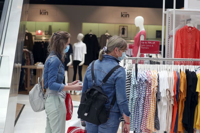 People looking at a rack of clothes