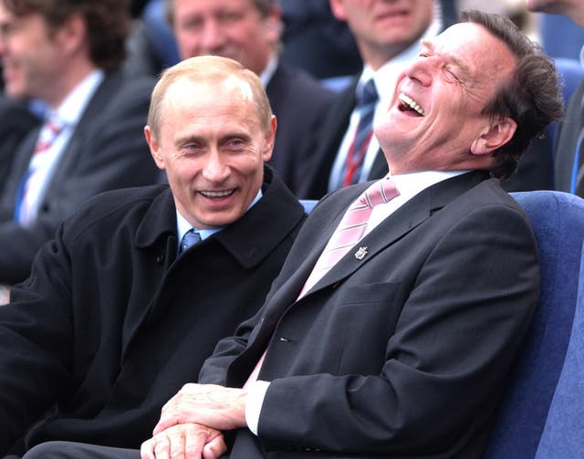 Russian leader Vladamir Putin (left) shares a joke with then German chancellor Gerhard Schroeder in St Petersburg (Stefan Rousseau/PA)