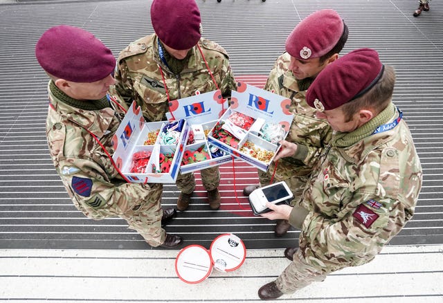 Armed forces personnel handing out poppies