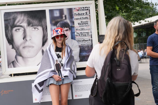 An Oasis fan poses for a photo on Wembley Way 