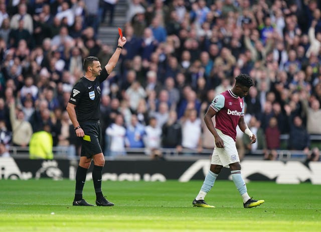 Referee Andrew Madley holds up a red card at West Ham’s Mohammed Kudus, who walks away.