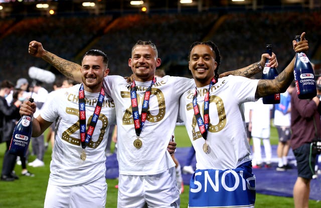 Phillips celebrates Leeds' promotion to the Premier League with Jack Harrison, left, and Helder Costa